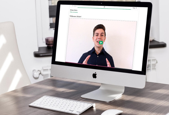 Aufnahme von einem Rechner. Auf dem Bildschirm ist ein Video mit einem Mann zu sehen.